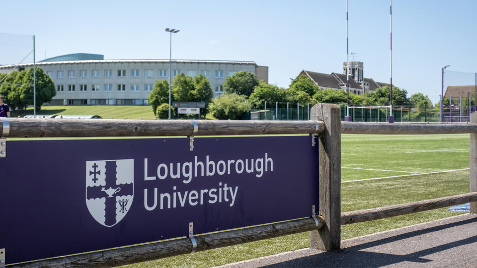 A purple Loughborough University banner in front of the Business School building