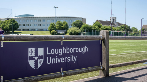 A purple Loughborough University banner in front of the Business School building