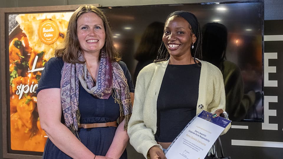 Justine Wood and Kamsi Daniella Ezeiruoma, with Kamsi holding an award certificate.