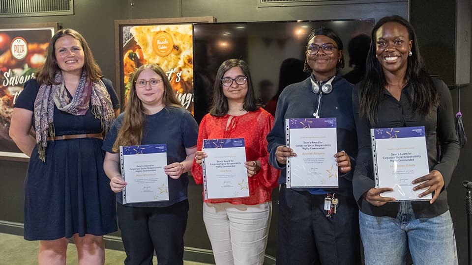 A group of students holding award certificates.