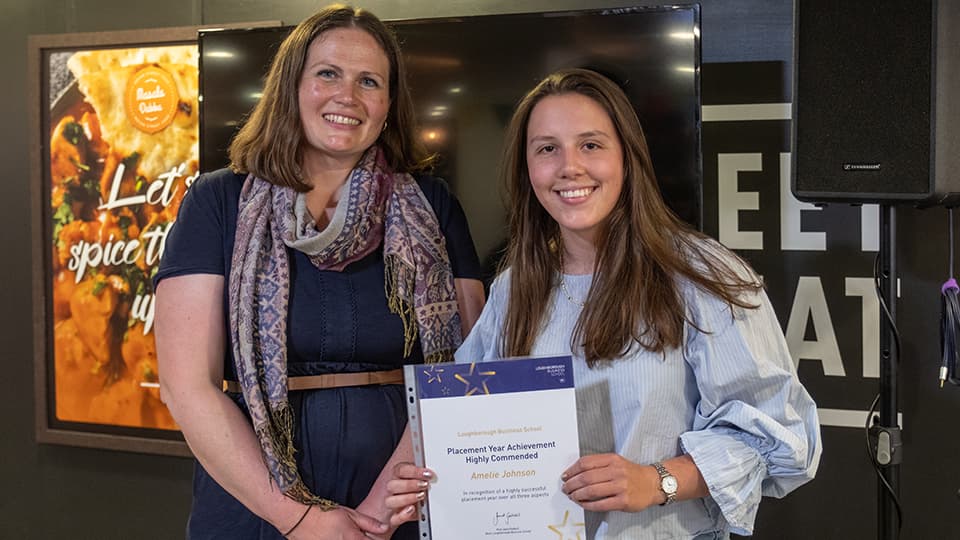 Justine Wood and Amelie Johnson, with Amelie holding an award certificate.