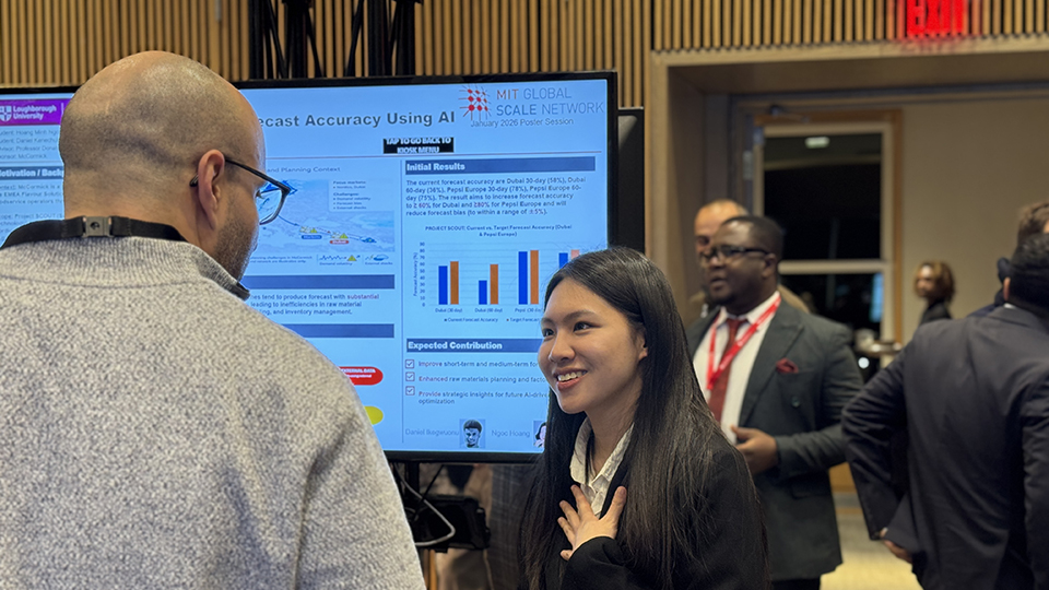 A UK SCALE student presenting a research poster on AI and forecast accuracy during the MIT Global SCALE Network Research Expo, speaking with an attendee.