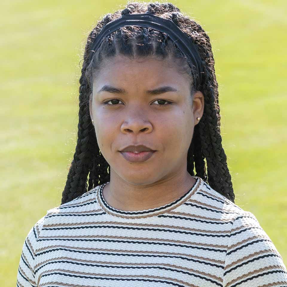 Portrait of K-Tricia Isaacs standing on grass