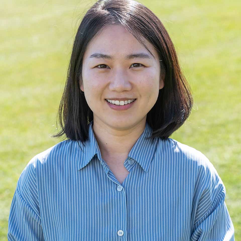 A portrait of Miri Lee standing on grass