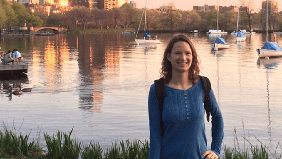 Chem Eng student, Arianna standing with a lake and boats in the background
