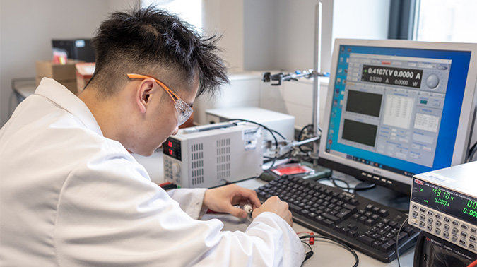 Carl working on testing batteries in lab.