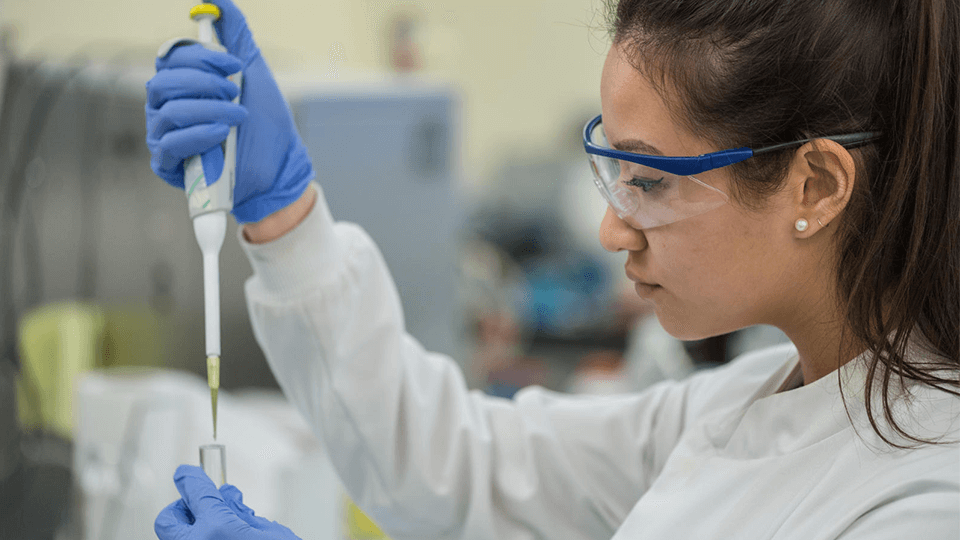 female research student holding a pipette