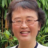 A headshot of Baihua Li with bamboo in the background