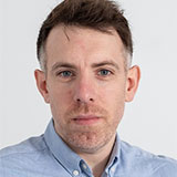 A headshot of Gary Storey wearing a blue shirt