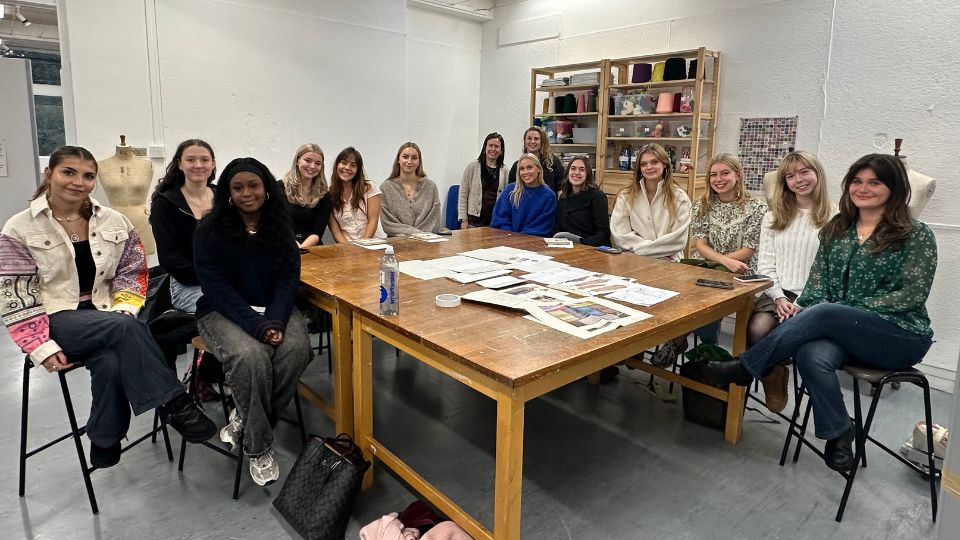 Second year shortlisted textiles students sat around a table with Sainsbury's Tu team