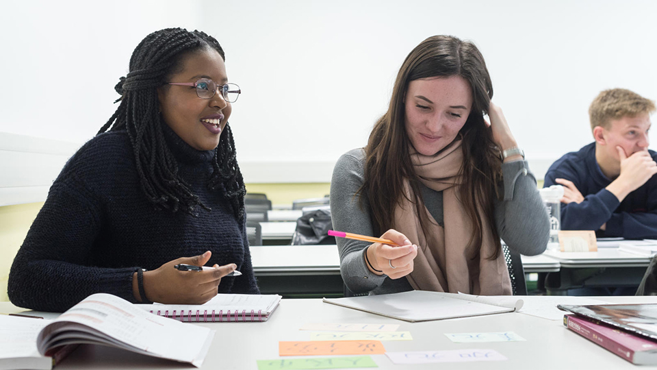 two female student writing notes during a lesson