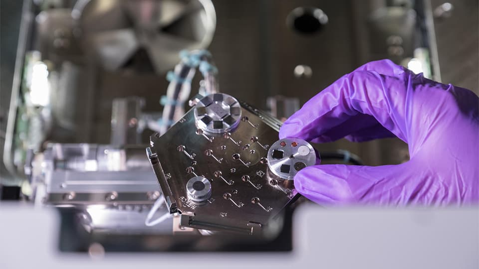 blue glove holding a screw