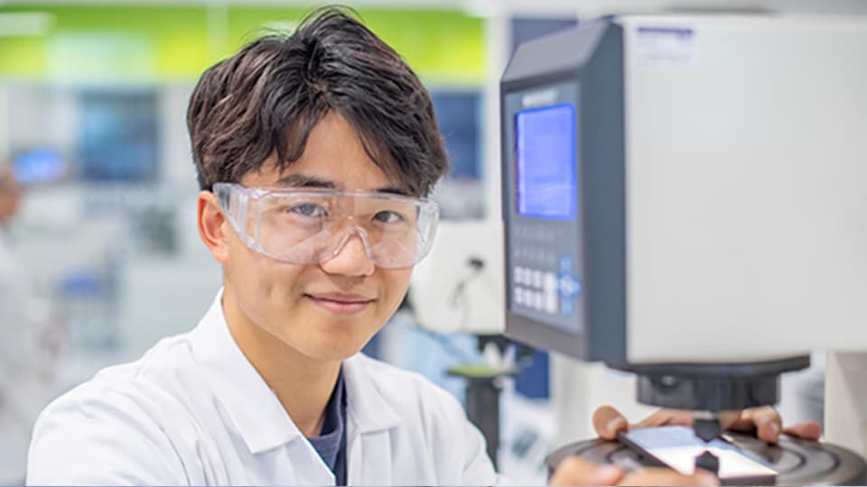 image of male student in a lab smiling at camera