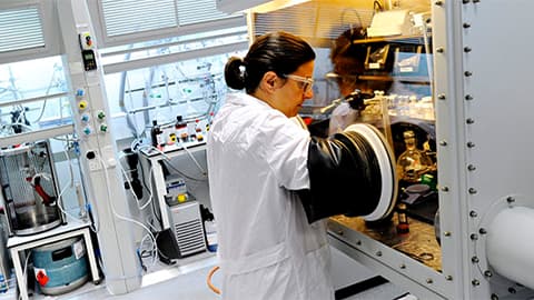 Woman in lab coat using equipment