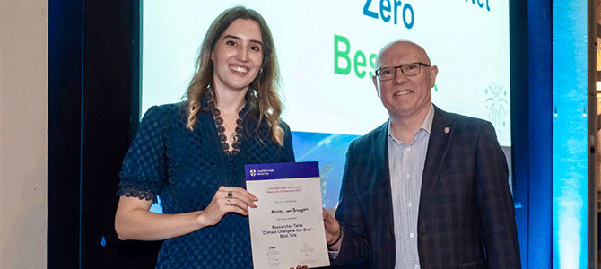 Ashley with academic holding certificate at researcher conference