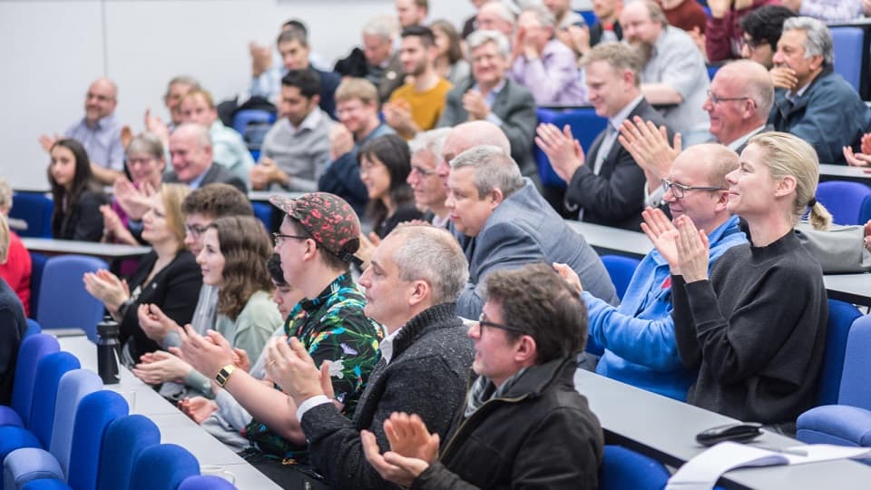 people clapping in the lecture theatre