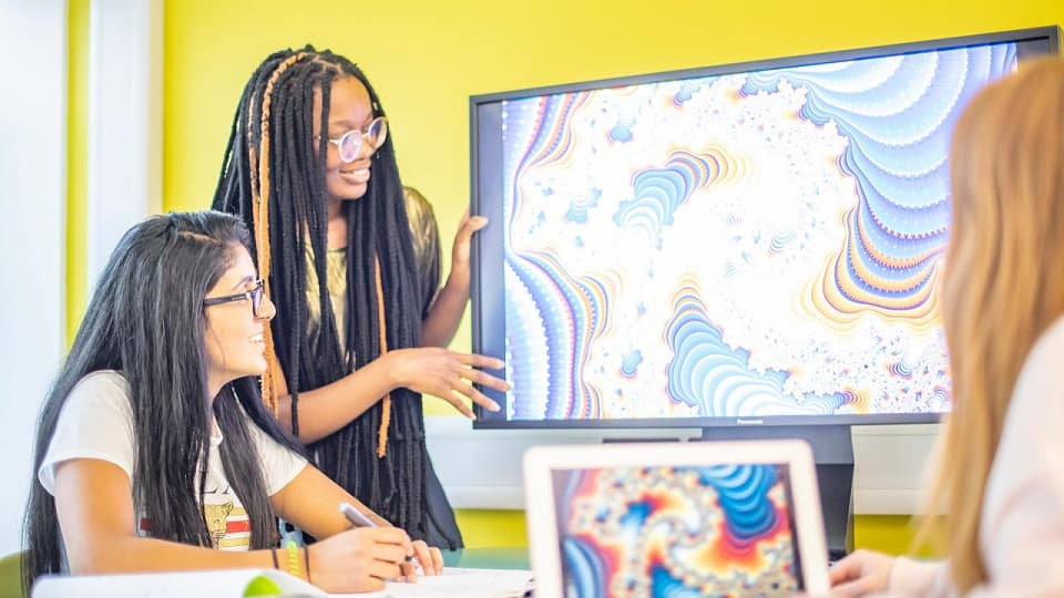 three students looking at the screen