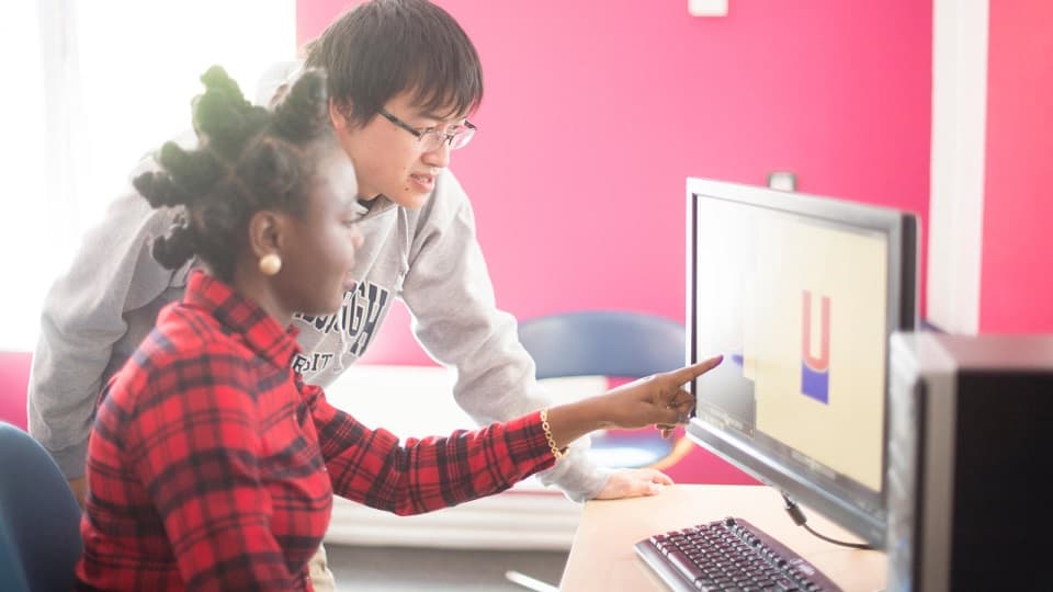 two students in front of a computer
