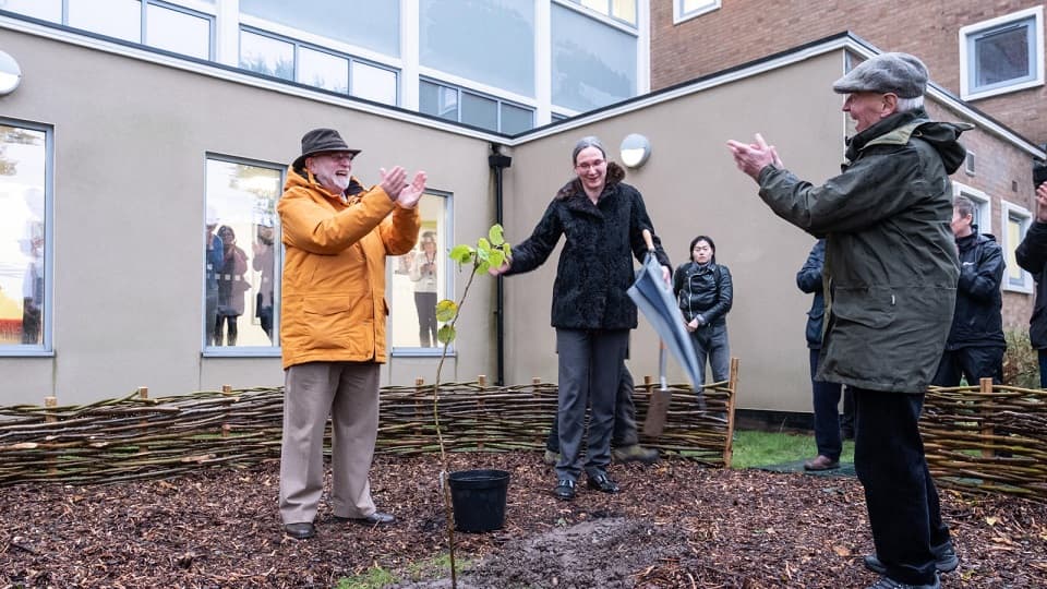 Two men outdoors talking cheerfully