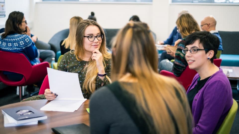 three students sitting working in a MEC lab