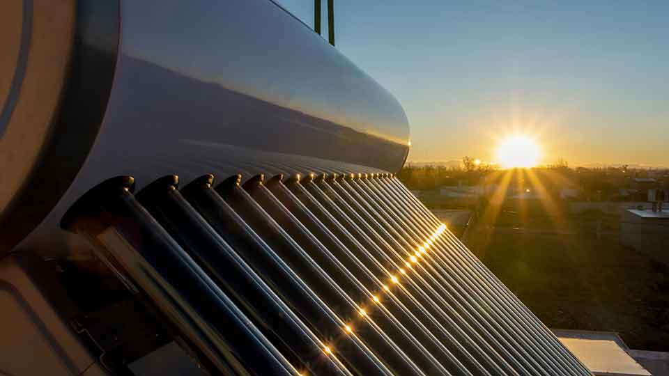 A solar hot water tank at sunset