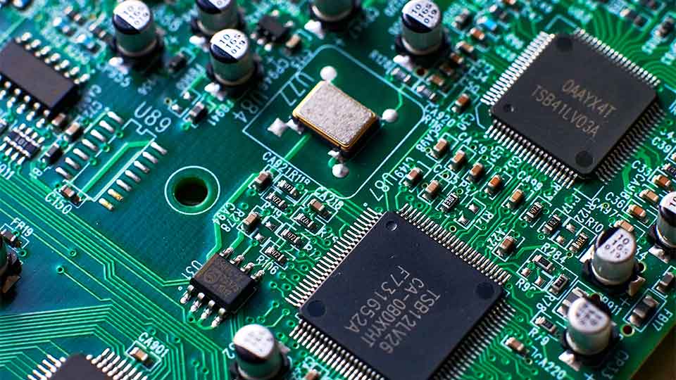 Blue, green and black coloured circuit board with radio components.