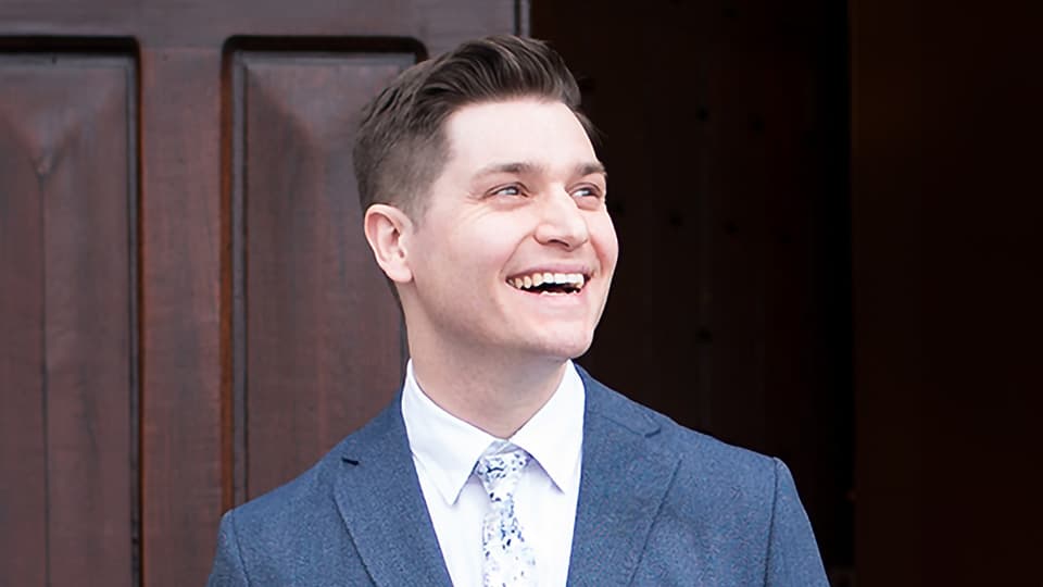 Chris stood outside by a university door