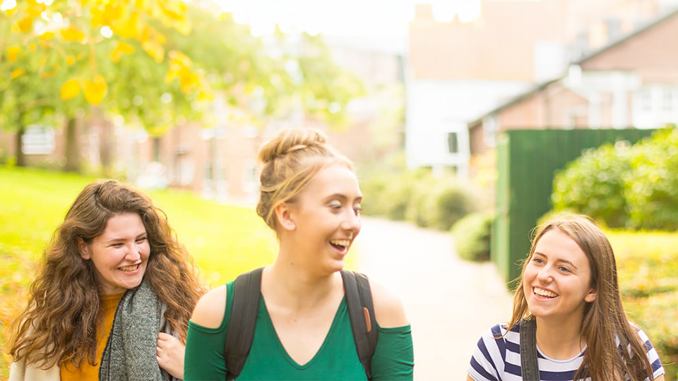 Three students on talking together on University campus