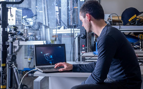 Student in engineering lab looking at cricket equipment