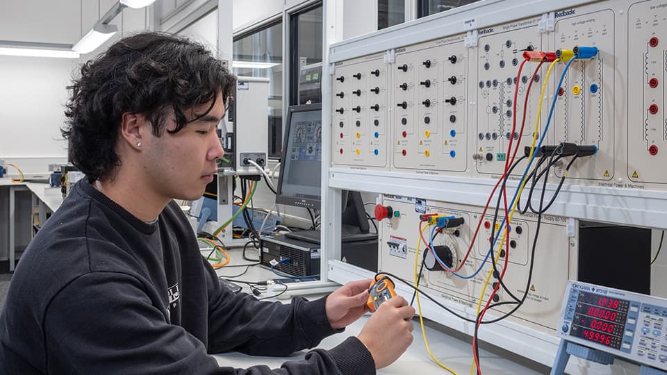 Students in engineering lab working with electrical engineering equipment