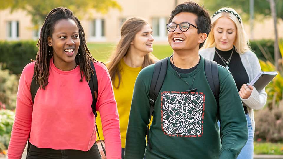 Student talking and laughing together on university campus