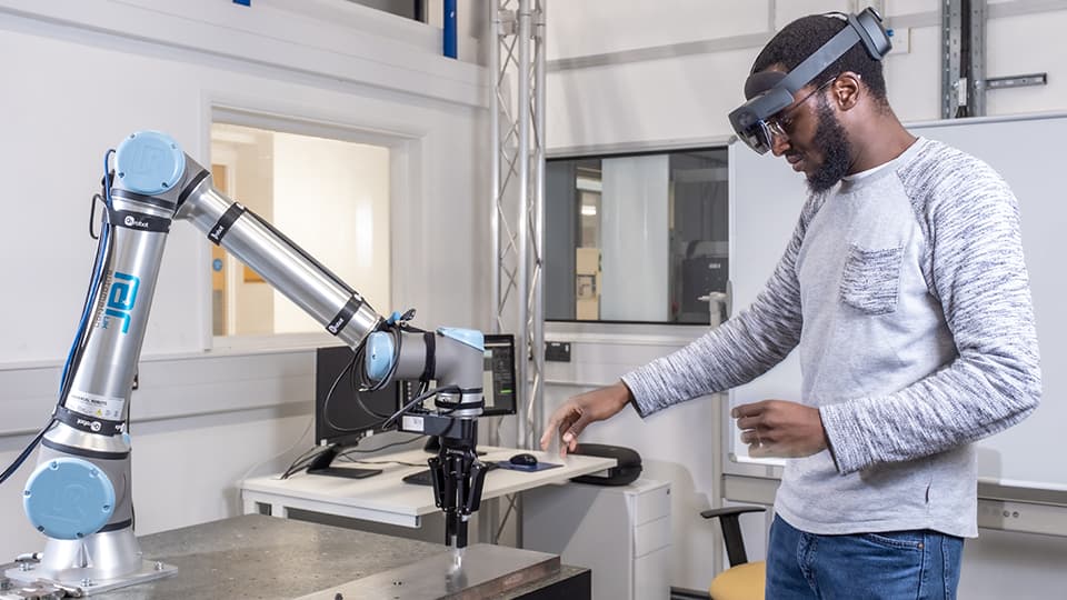 Engineering student working with a engineering robotic arm