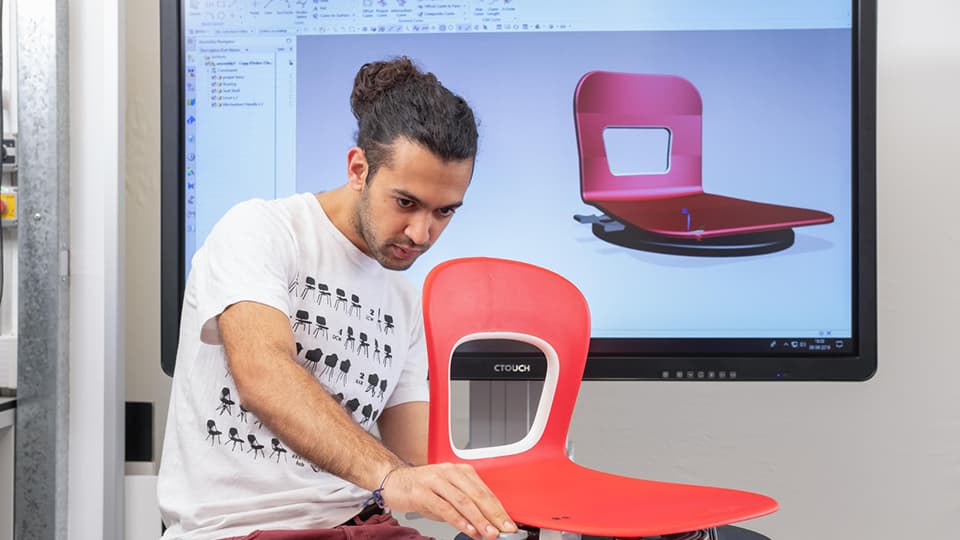 Student in engineering lab working on a computer screen with a 3D object