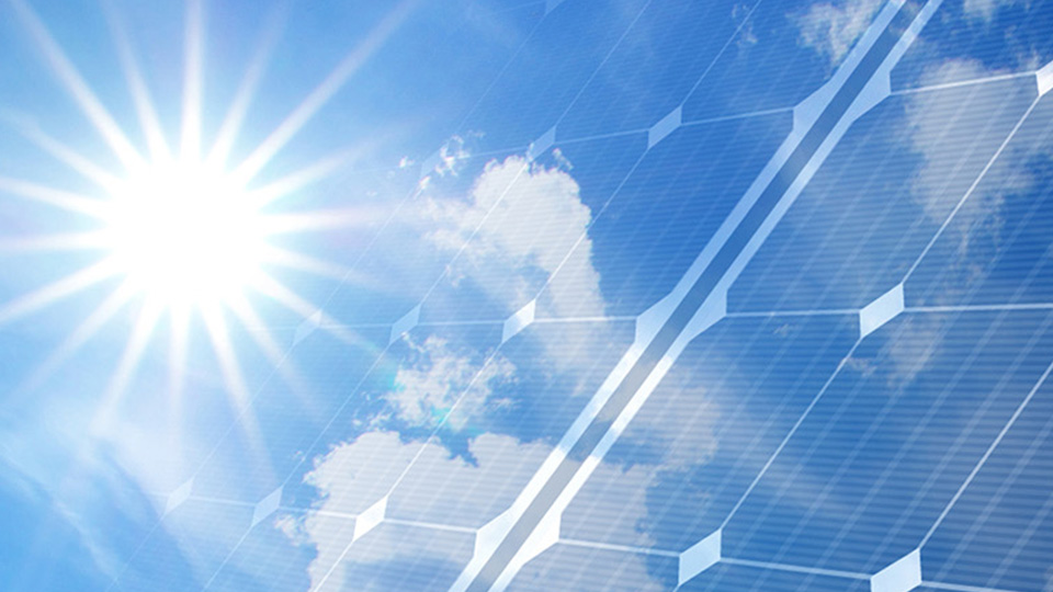 Sun in blue sky shining on solar panels