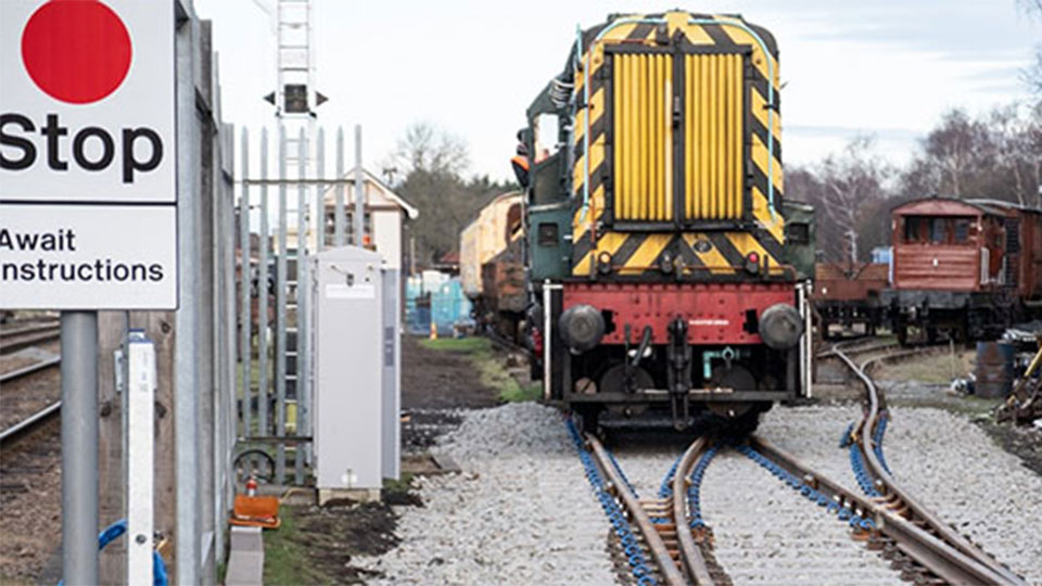 Stationary train on an unused train-track with a sign that reads 