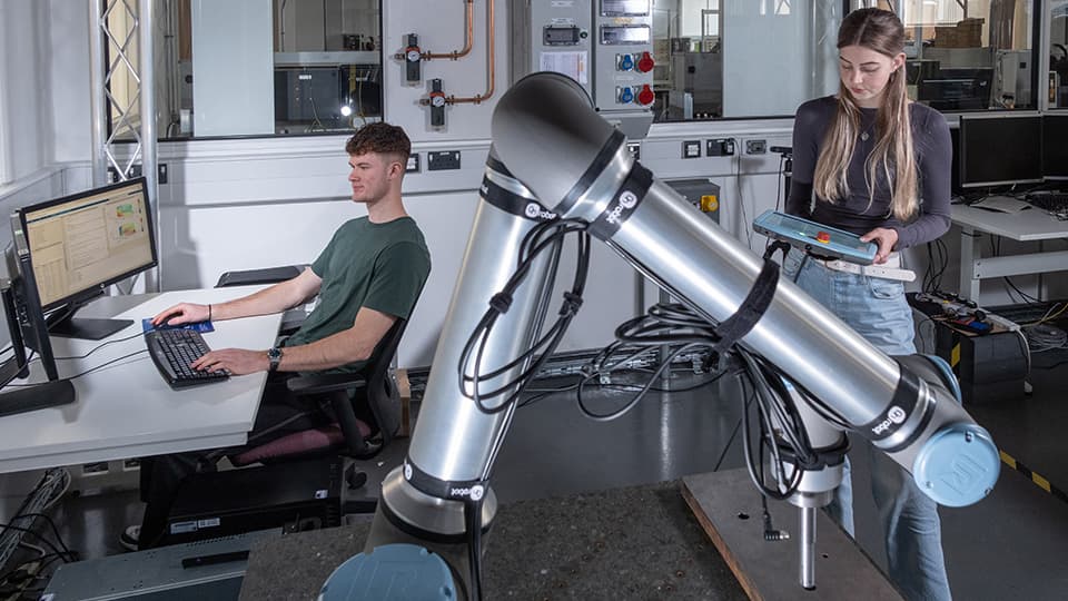 Students in engineering lab working on engineering equipment