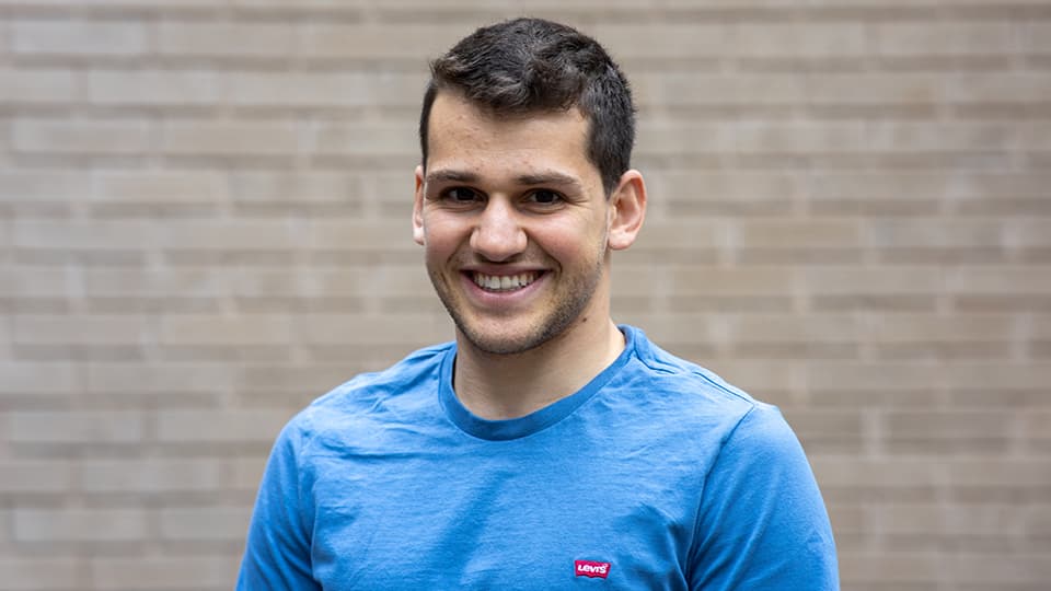 Adam stood next to a brick wall