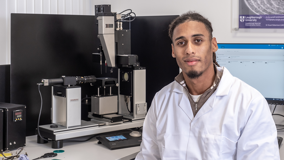 Alex with his engineering equipment sat by a computer