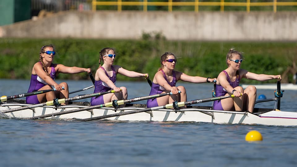 Lottie rowing with her team mates down a river