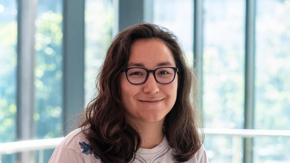 Mathilde stood by university windows