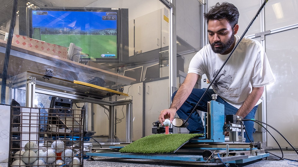 Student in sports engineering lab testing golf equipment