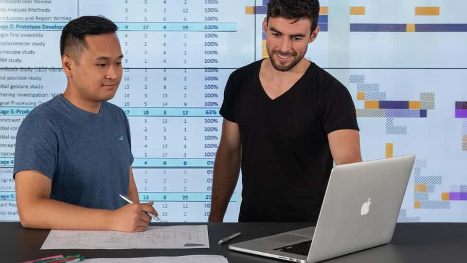 Student in engineering lab with large screen of information behind them