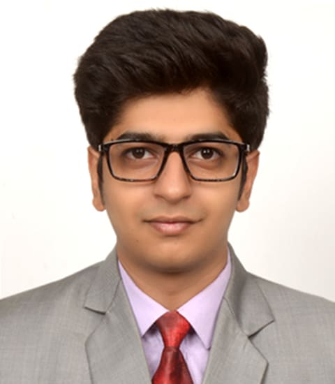 Tushar wearing a business suit and glasses