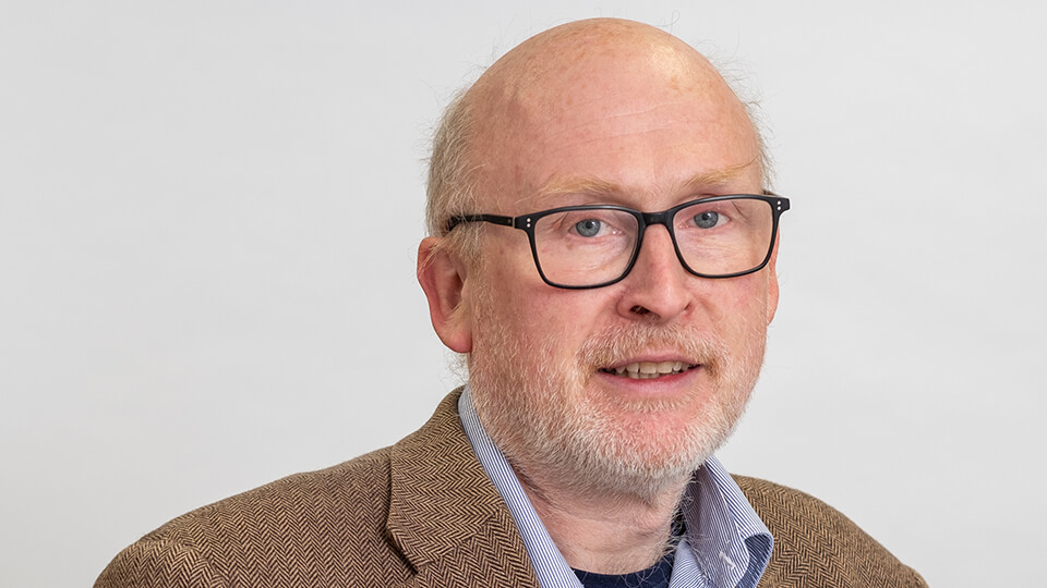 Headshot of Phil, looking directly at the camera whilst smiling.
