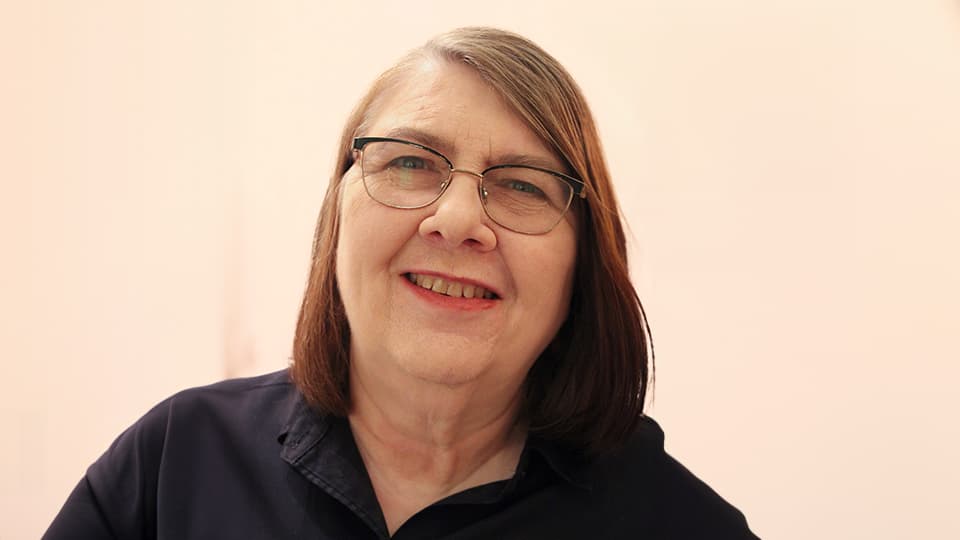 Sarah in front of a cream wall