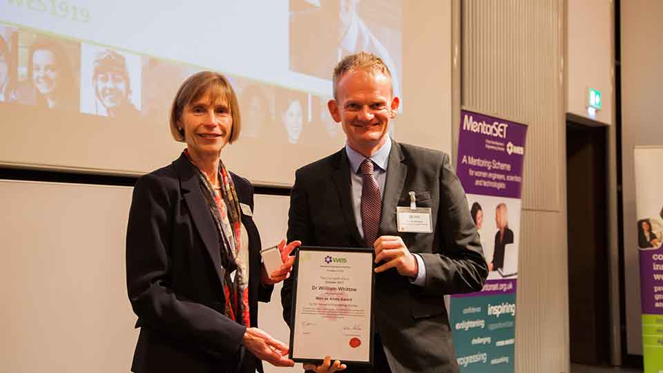 Will standing with a female holding a certificate.