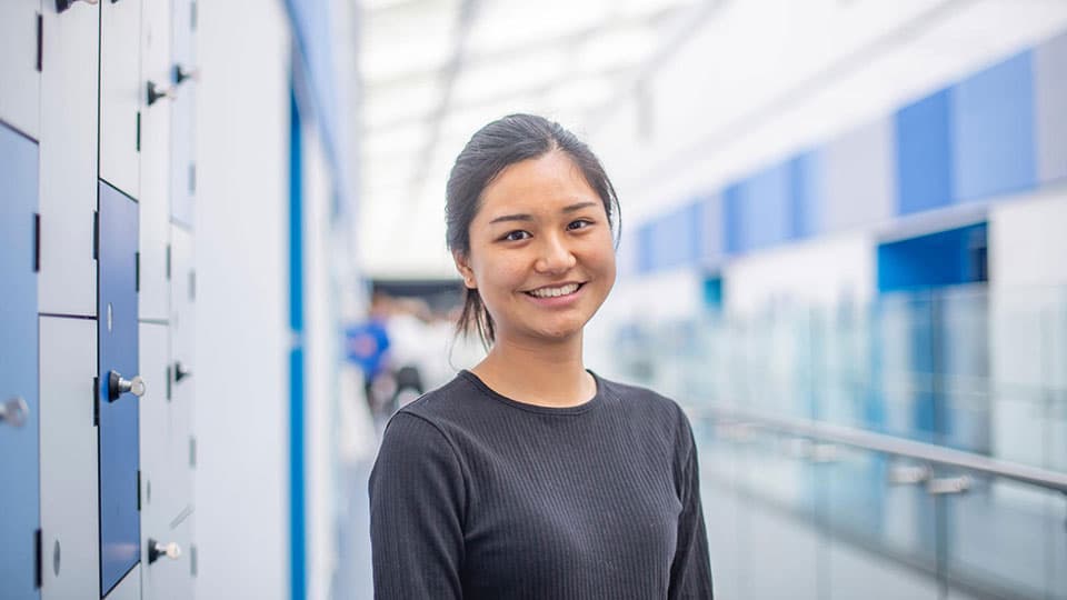 A student standing in a central corridor of the STEMLab facility.