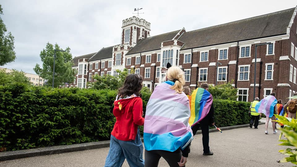 People walking past the Hazlerigg building as part of the LGBT+ Pride March on campus