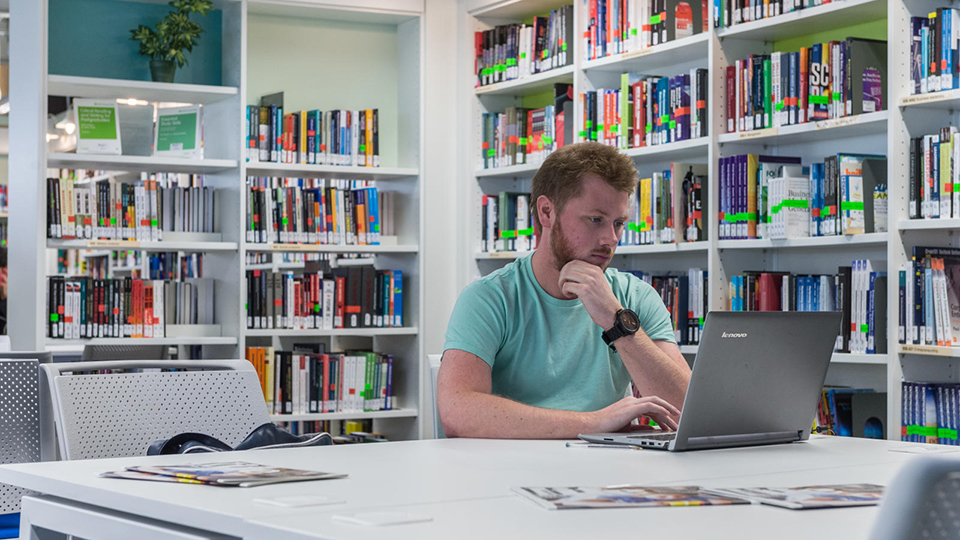 Student with laptop in library