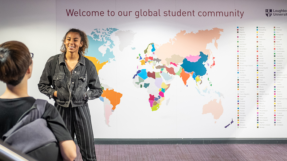 Students talking in front a map of the world